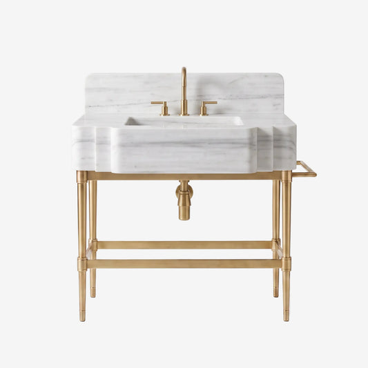 A modern bathroom vanity featuring a white marble sink and backplate with a brushed gold faucet, handles, and metal stand, shown against a clean white background.