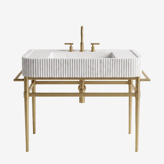 A modern bathroom vanity set featuring a white rectangular sink with a ribbed front, mounted on a gold-finished metal frame with a matching tall faucet and cross-handle fixtures, shown against a plain white background.