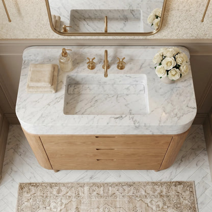 Carrara White marble bathroom vanity with integrated sink, matching backsplash and natural oak cabinet