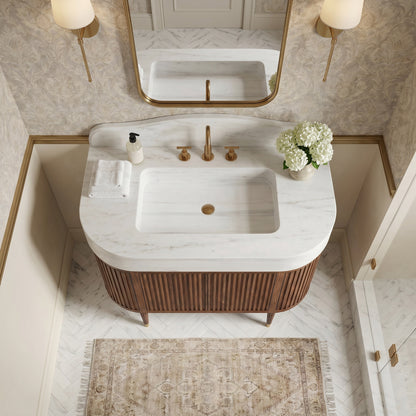 Custom Carrara marble bathroom vanity with integrated sink, sculptural curved backsplash and fluted walnut cabinet